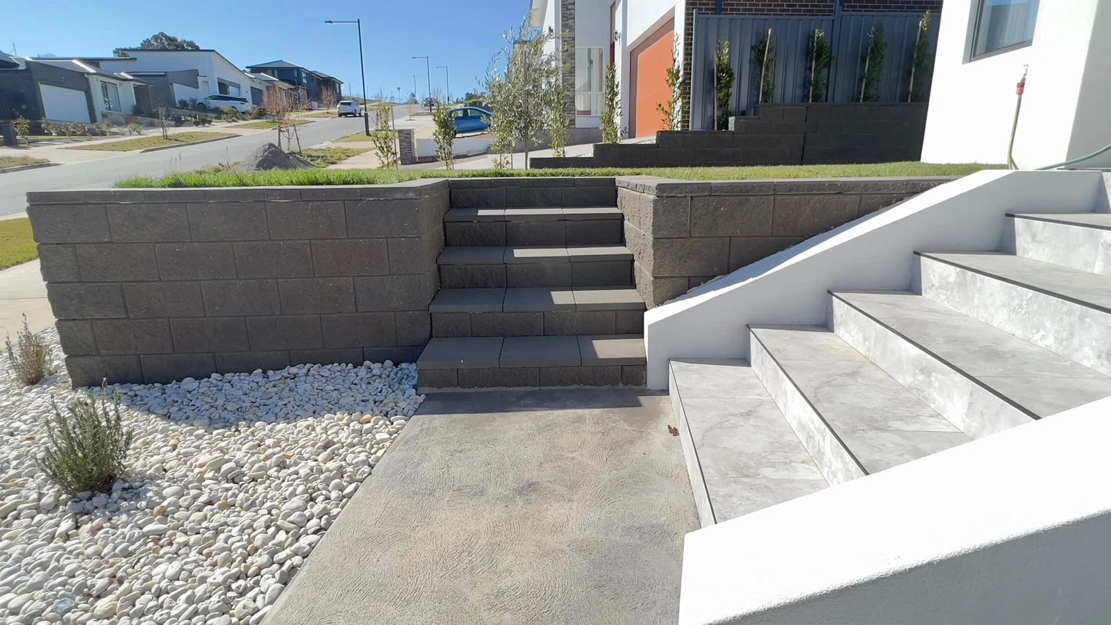 Block retaining wall with steps and gravel landscaping