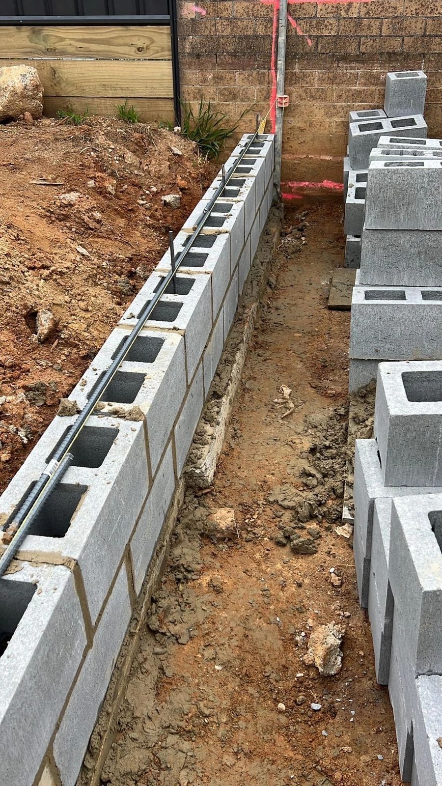 Block retaining wall under construction by Brick Projects
