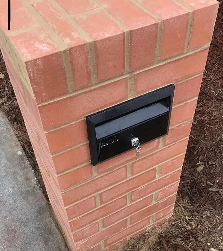 Red brick mailbox with black letter insert